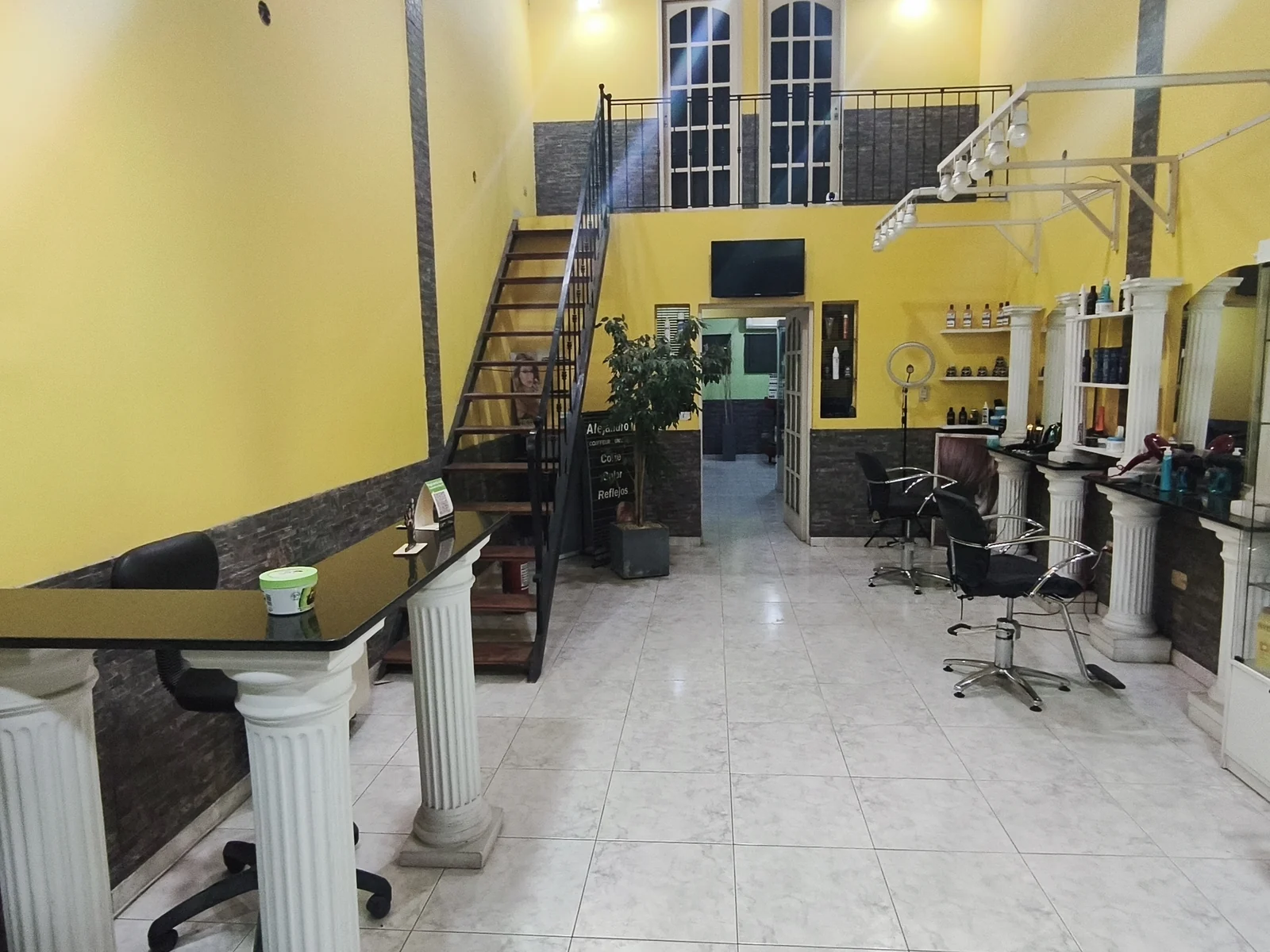 La recepción del salón, con la escalera y las columnas blancas
