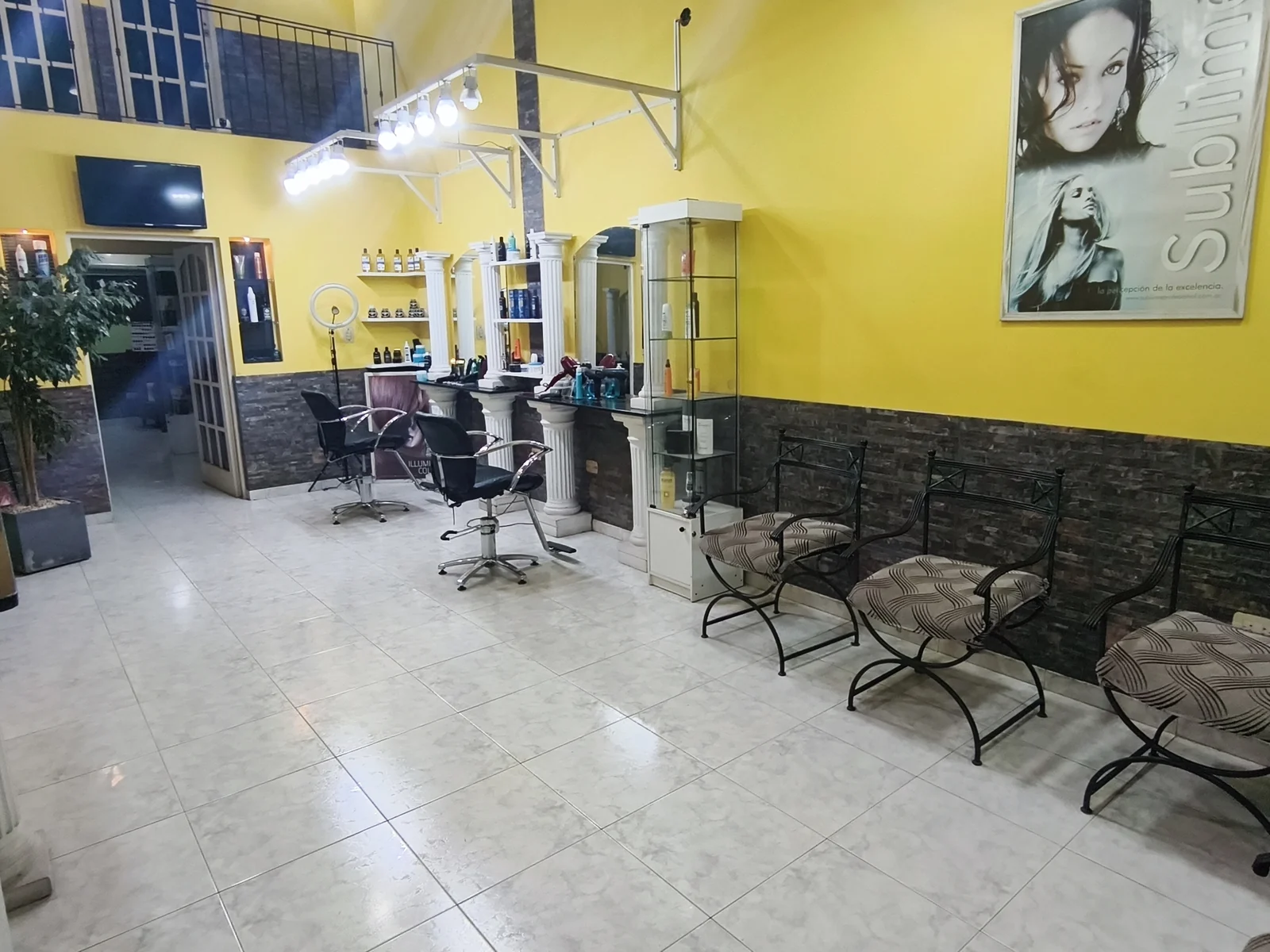 La sala de espera: sillones de hierro frente a los espejos y la pared amarilla